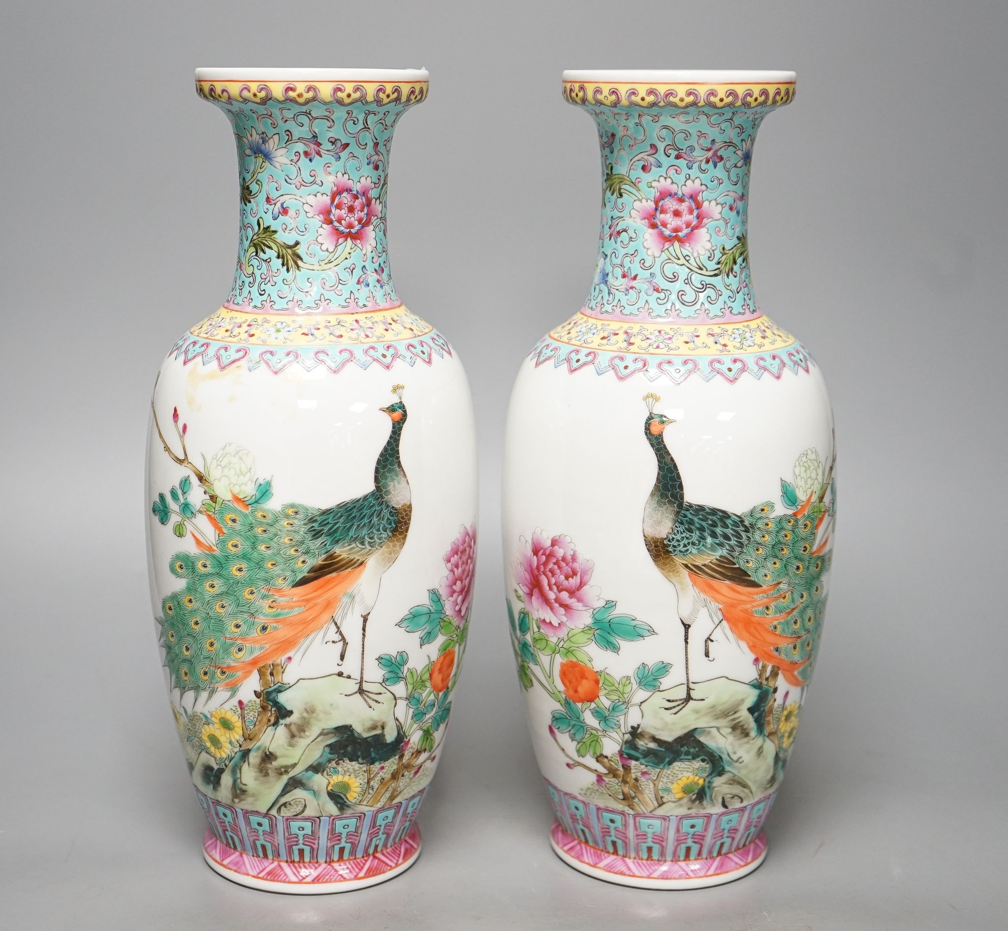 A pair of Chinese famille rose vases decorated with peacocks, 31cm